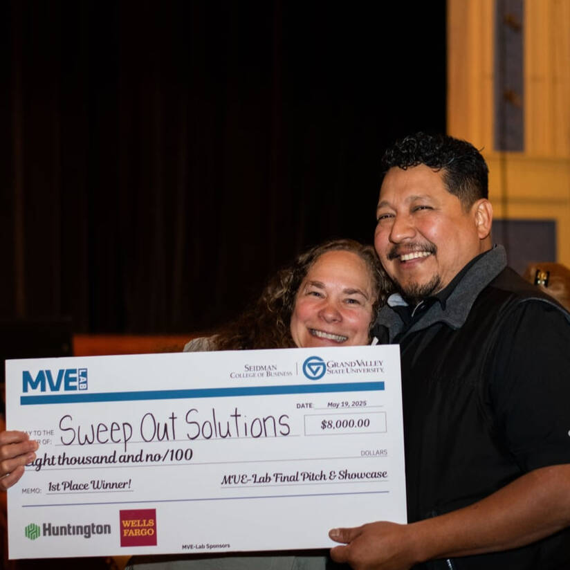 Two people holding an award check as winners of the recent MVE Lab based in Traverse City